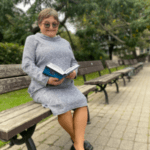 Skolotāja Māra Ozola ar grāmatu parkā