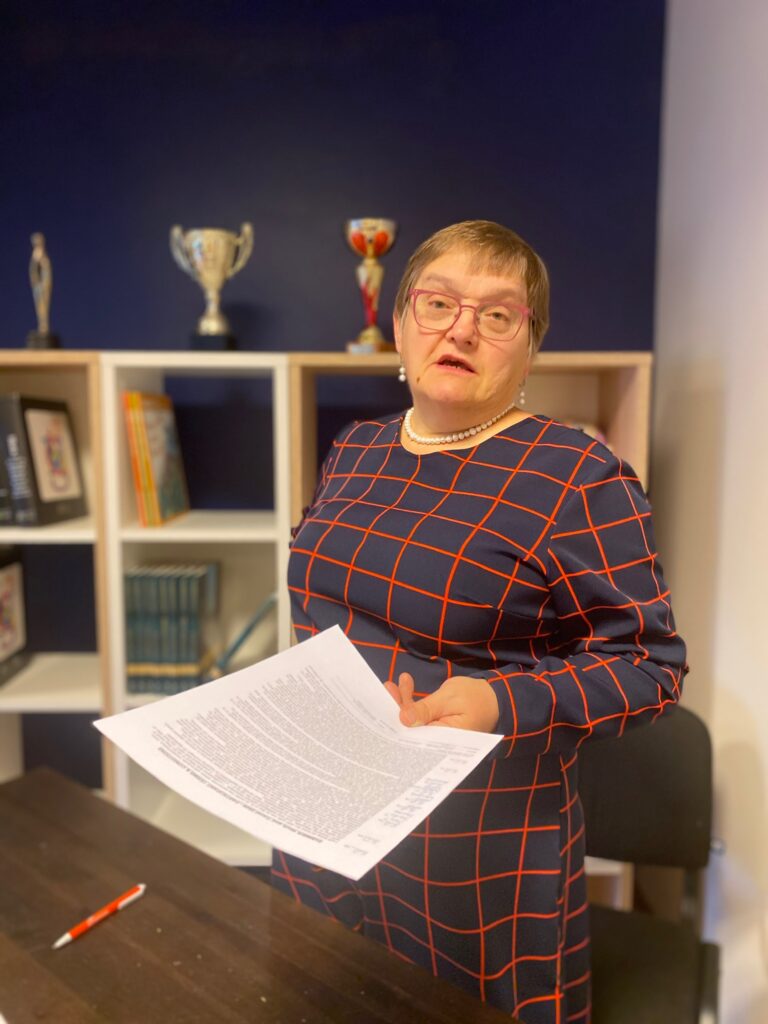 Skolotāja Māra Ozola ar dokumentu rokā