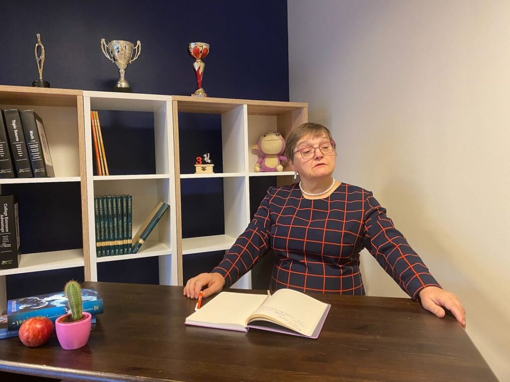 Skolotāja Māra Ozola pie galda domīga